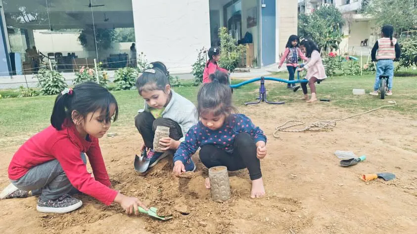 Children exploring outdoor gardens in a half-acre green campus at Productive Minds preschool in Gurgaon