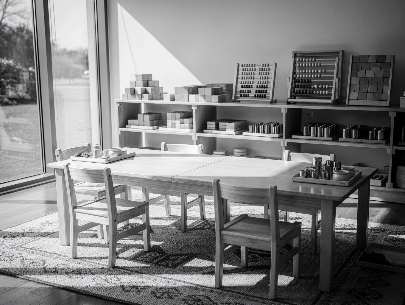 Toddler naturally preparing snack at a child-height natural wooden Montessori kitchen station