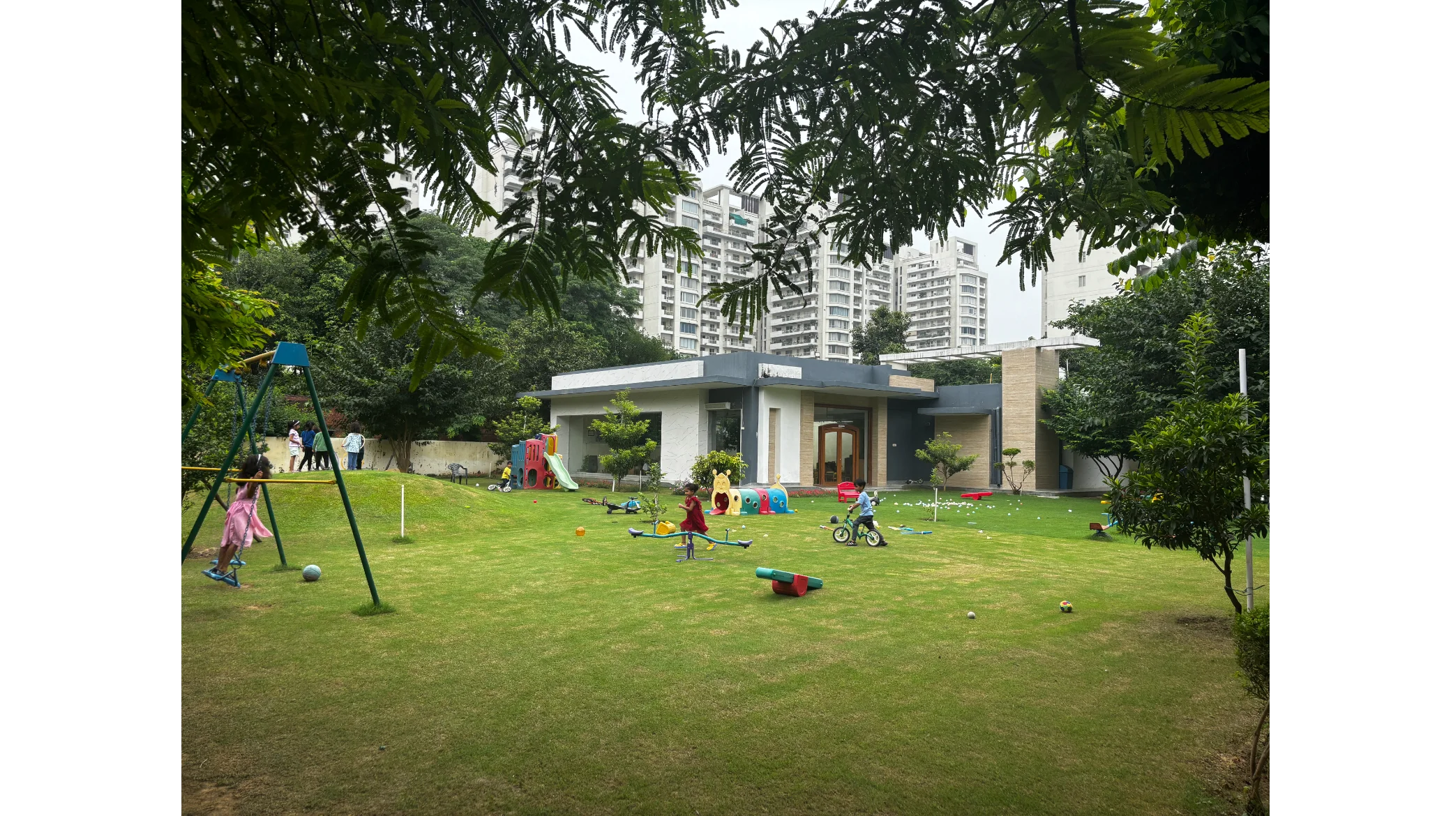 Children playing across the huge green preschool campus grounds
