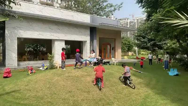 Young children exploring natural materials and plants in the outdoor garden