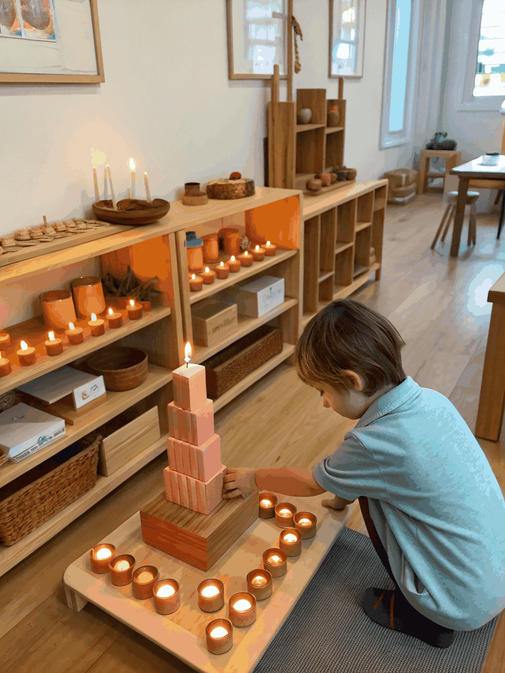 A preschool child deeply absorbed in purposeful Montessori wooden cylinder work on a natural woven mat