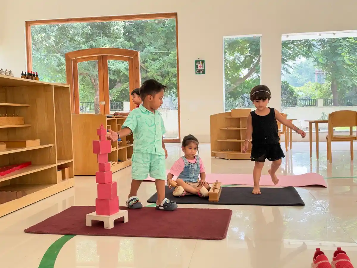 Toddlers engaged in Montessori sensorial activities