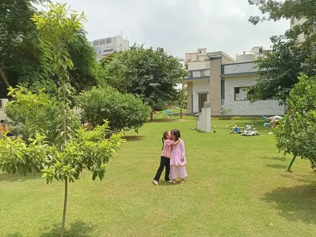 Two children hugging on the huge green Sector 65 campus