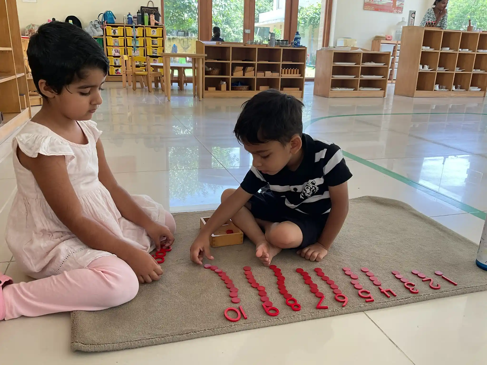 Toddlers deeply focused on individual sensorial and practical-life apparatus during work cycles